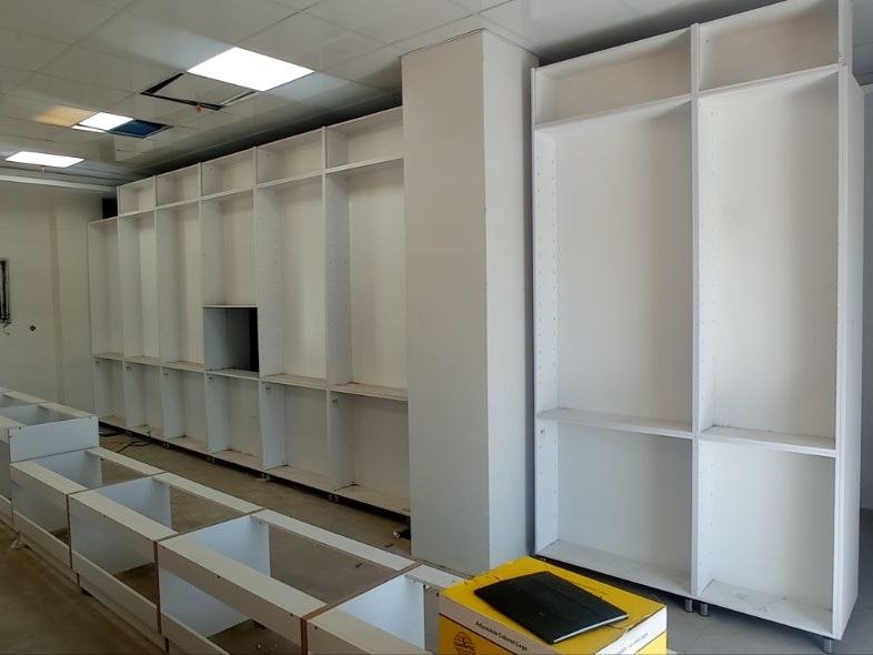 نصب و چیدمان کابینت‌های سفید در فضای داخلی در حال ساخت
